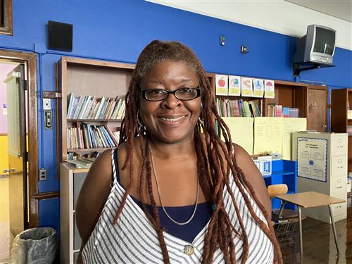 School Social Worker a white and blue top, glasses, braids and smiling..
